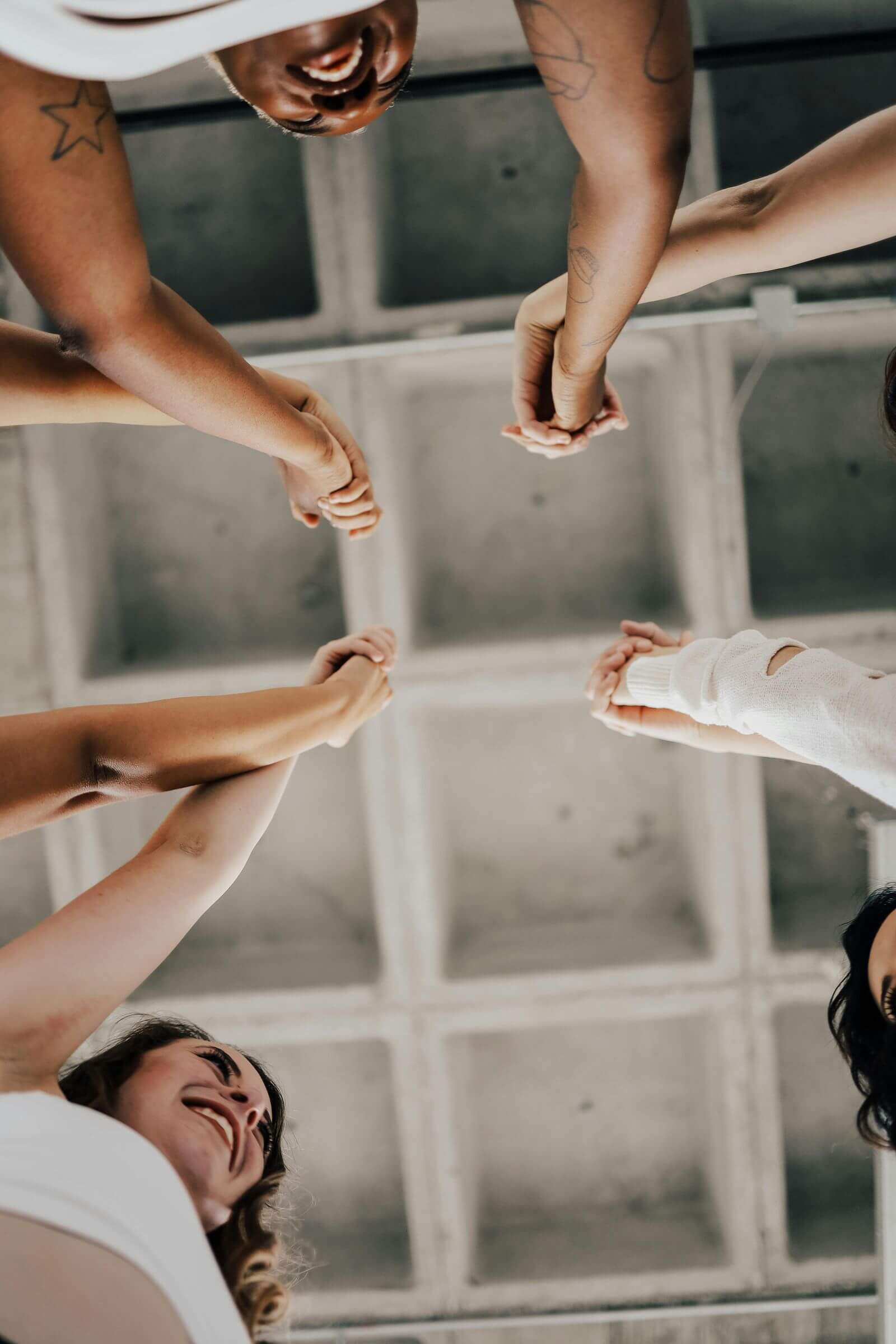 A circle of individuals of various ethnicities and genders holding hands, representing harmony and togetherness.